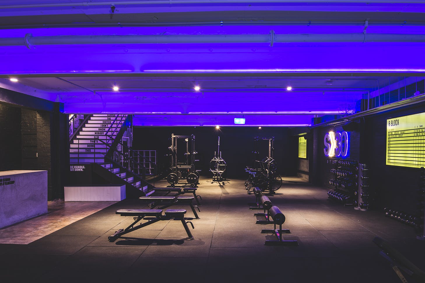 the interior of a dark, black and purple gym room